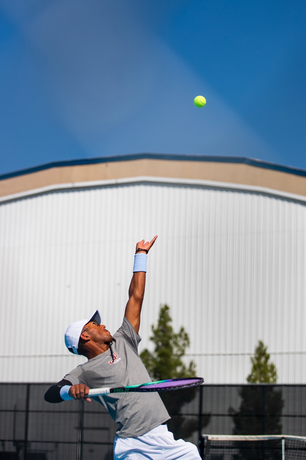 Philip Kamara serving during an ITA NCAA Division II regional championship match